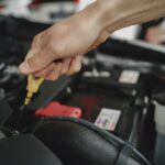 Sprawdzanie poziomu oleju bagnetem w komorze silnika Nissana