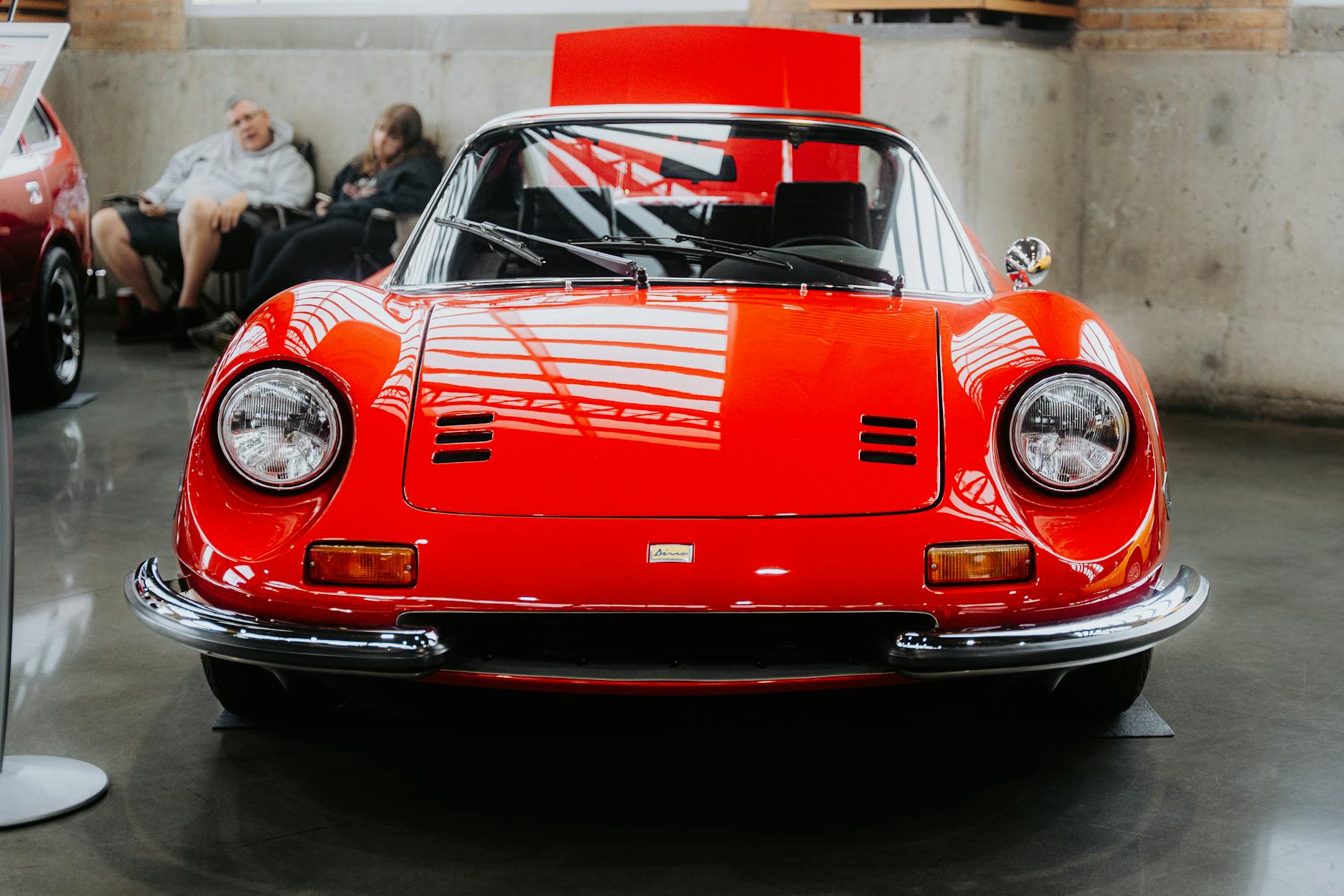 Czerwone klasyczne Ferrari przodem na ekspozycji podczas salonu samochodowego