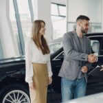 Jak negocjować cenę używanego Rolls‑Royce w salonie premium i u prywatnych sprzedawców Klient podaje dłoń sprzedawcy przy zakupie używanego Rolls-Royce w salonie