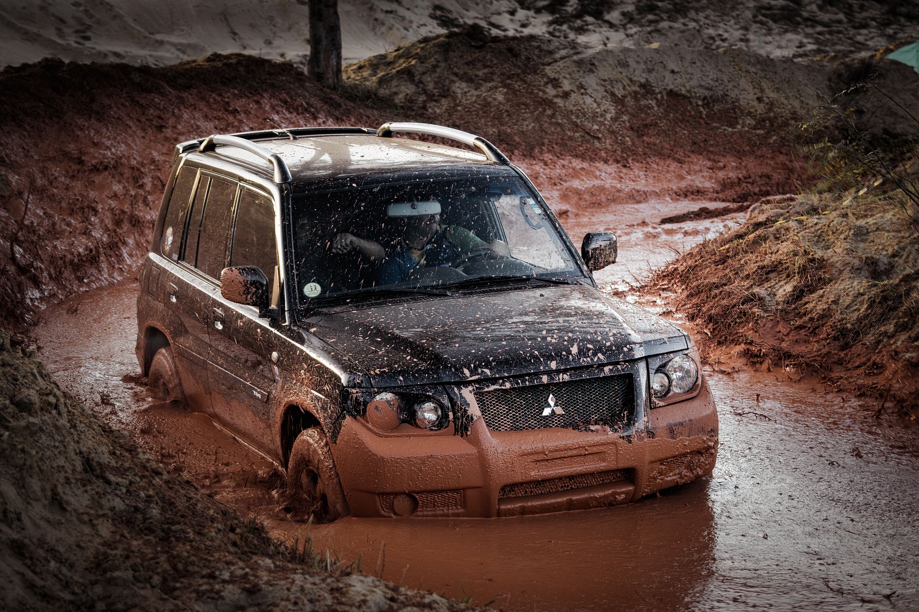 Mitsubishi SUV podczas jazdy w błotnistym terenie offroad