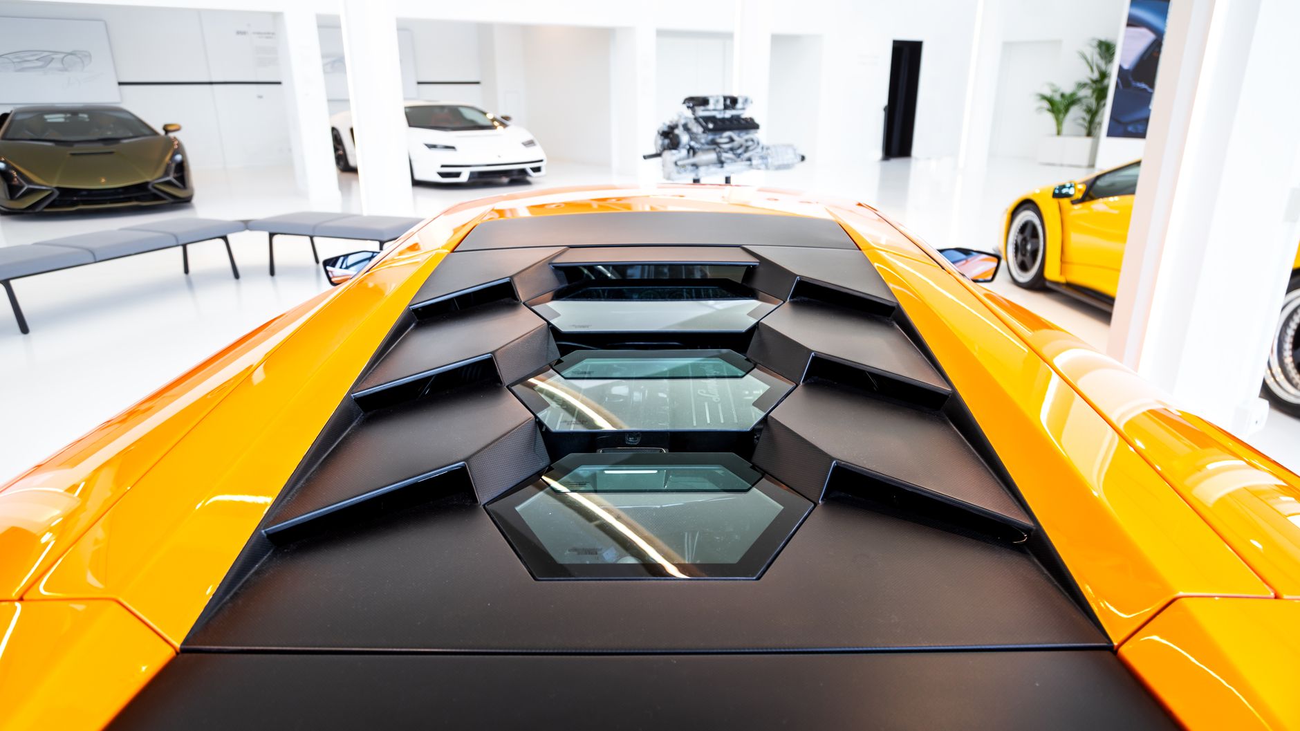 Pomarańczowy Lamborghini Aventador, detal pokrywy silnika w showroomie