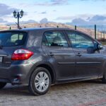 Renault Laguna III jako tanie auto klasy średniej – analiza opłacalności zakupu po 2020 roku Szary Toyota Auris zaparkowany na zewnątrz, w tle wzgórza i chmury