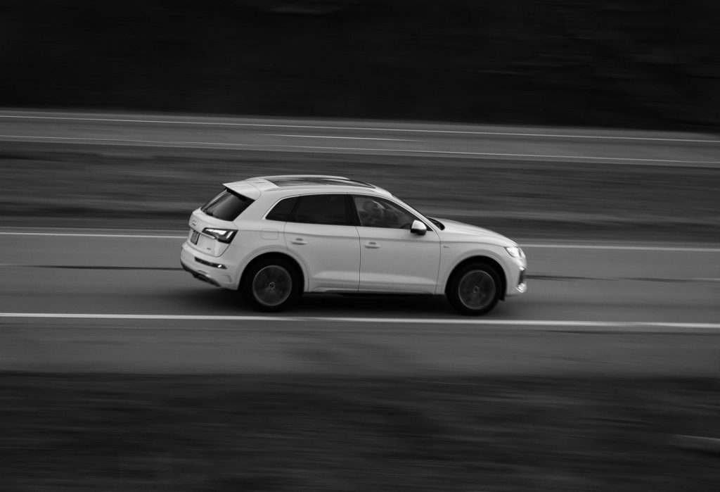 Biały SUV jadący pustą drogą